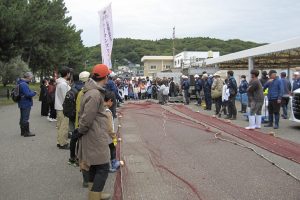 Participants receiving an explanation from Fisheries Cooperative members about the seine net